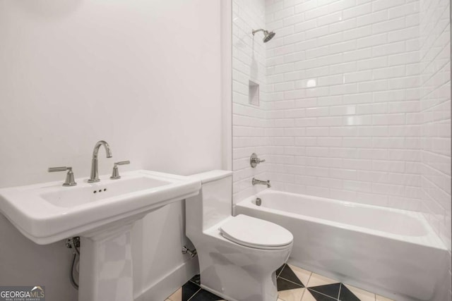 full bathroom with tiled shower / bath, sink, toilet, and tile patterned flooring