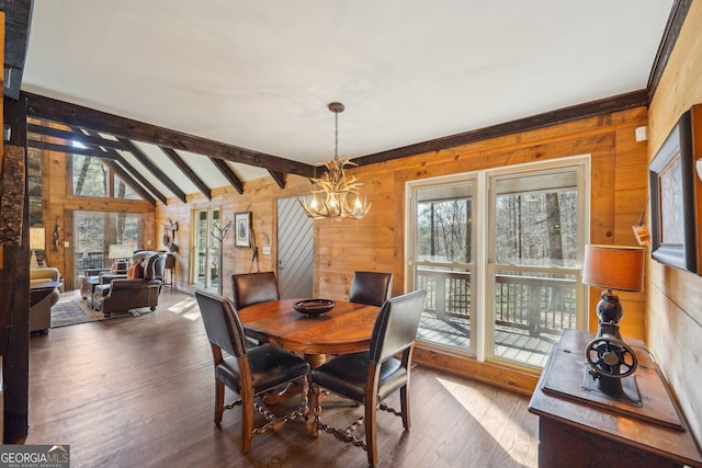 dining room featuring hardwood / wood-style flooring, wood walls, lofted ceiling with beams, and a notable chandelier