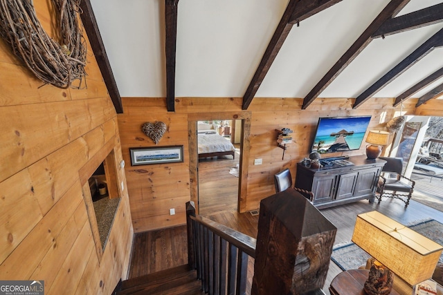 staircase featuring hardwood / wood-style floors, beam ceiling, and wood walls