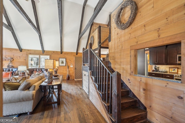 living room featuring dark hardwood / wood-style flooring, vaulted ceiling with beams, and wood walls