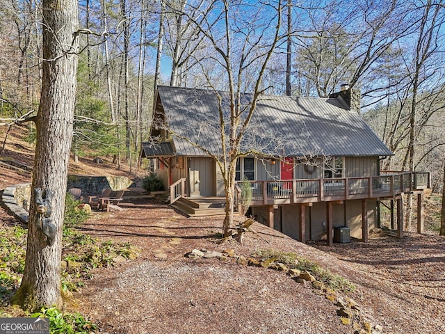 back of house with a deck and central air condition unit