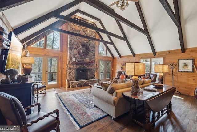 living room with dark hardwood / wood-style flooring, a fireplace, french doors, and wood walls