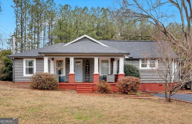 view of front of house with covered porch and a front yard