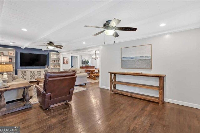 living room with dark hardwood / wood-style flooring, ceiling fan with notable chandelier, beam ceiling, and built in shelves