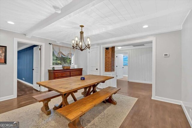 dining area with dark hardwood / wood-style flooring, crown molding, an inviting chandelier, and beam ceiling