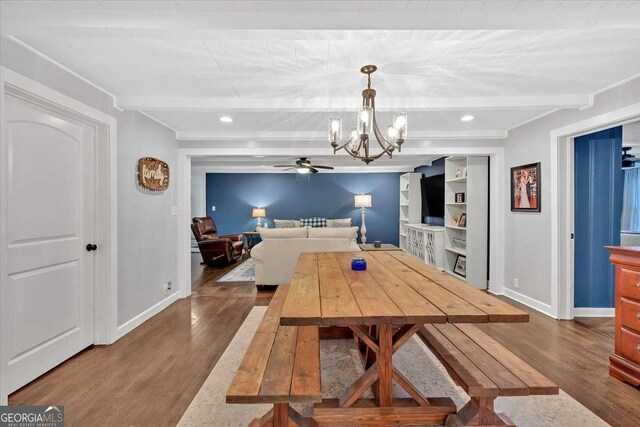 dining area featuring ceiling fan with notable chandelier, dark hardwood / wood-style floors, and beamed ceiling