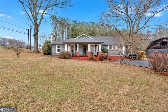 ranch-style house featuring a porch and a front lawn