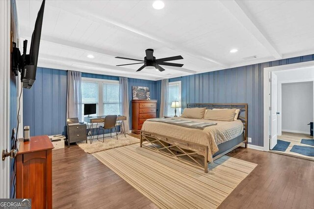 bedroom featuring ceiling fan, dark hardwood / wood-style floors, and beamed ceiling