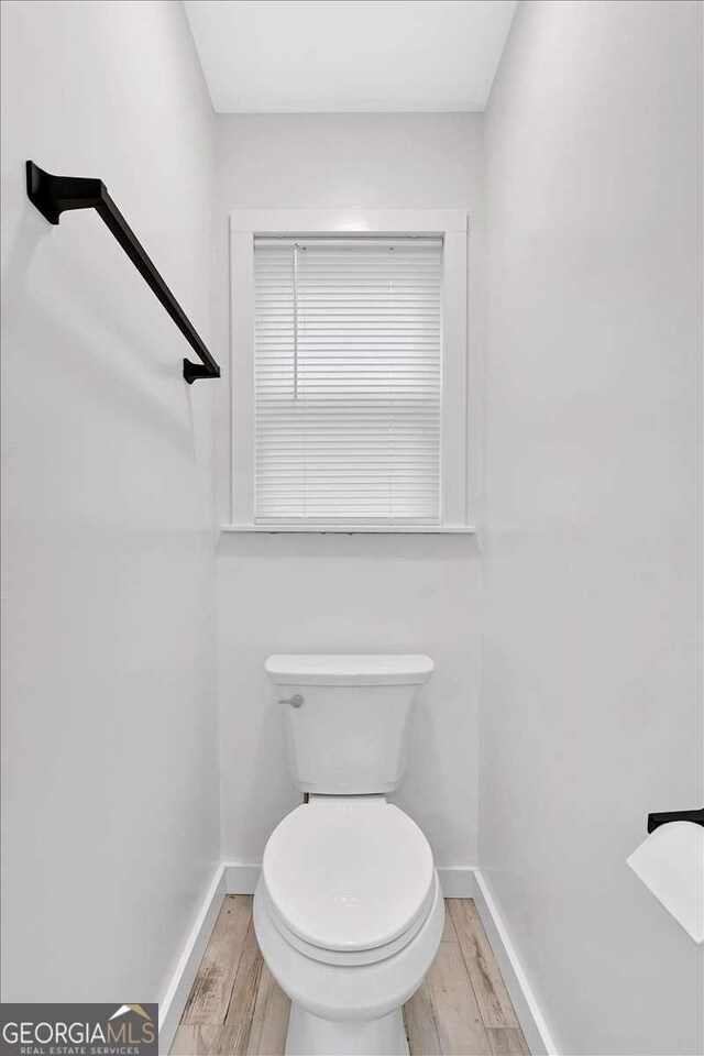 bathroom featuring wood-type flooring and toilet