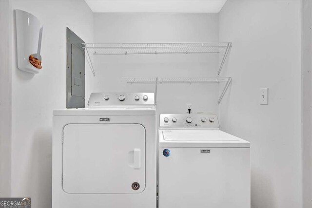 washroom with electric panel and washer and dryer