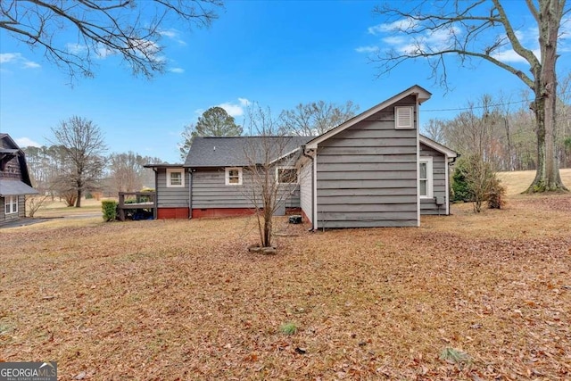 back of property with a wooden deck and a yard