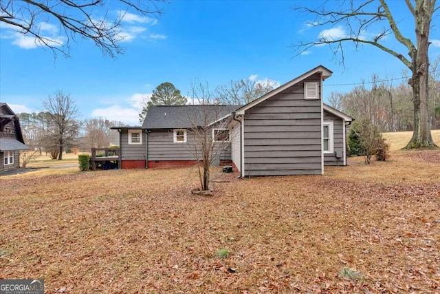 rear view of house with a lawn and a deck