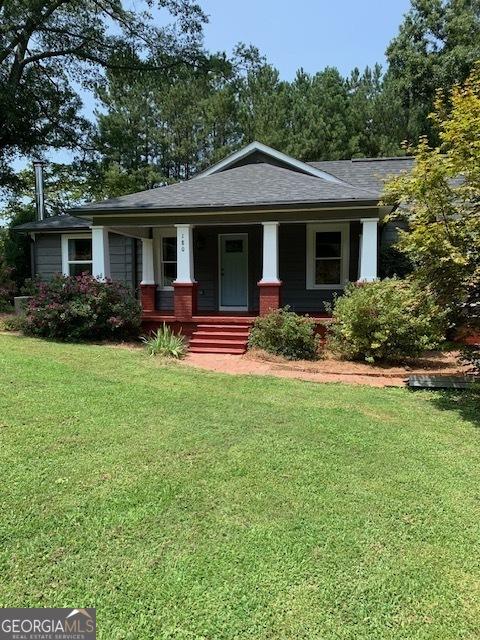 view of front facade with a front yard and covered porch