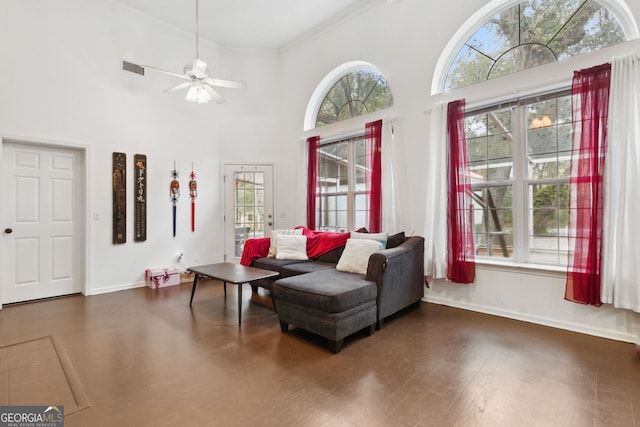 living area featuring a high ceiling, crown molding, a wealth of natural light, and ceiling fan