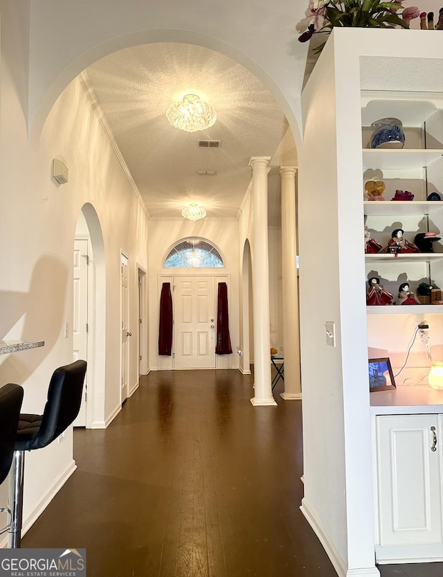 hall with built in features, dark hardwood / wood-style floors, and a textured ceiling