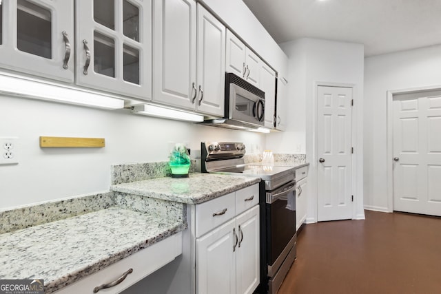 kitchen featuring white cabinetry, light stone counters, and stainless steel appliances