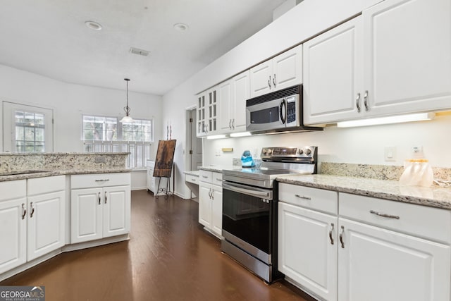 kitchen with stainless steel appliances, hanging light fixtures, and white cabinets