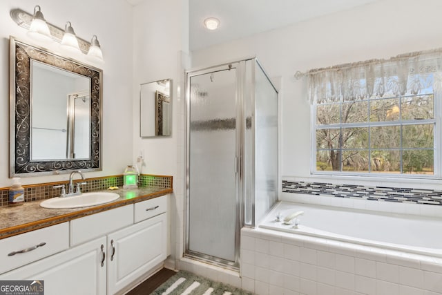 bathroom featuring vanity, tasteful backsplash, and plus walk in shower