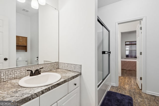 bathroom with tasteful backsplash, vanity, and toilet