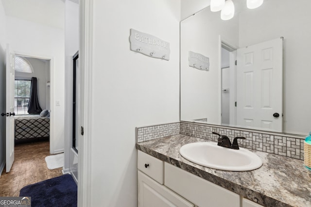 bathroom featuring tasteful backsplash, vanity, and hardwood / wood-style floors