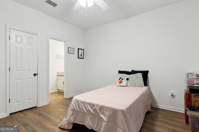 bedroom featuring ensuite bath, dark wood-type flooring, and ceiling fan