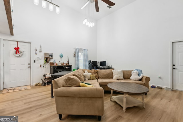 living room featuring ceiling fan, high vaulted ceiling, and light wood-type flooring