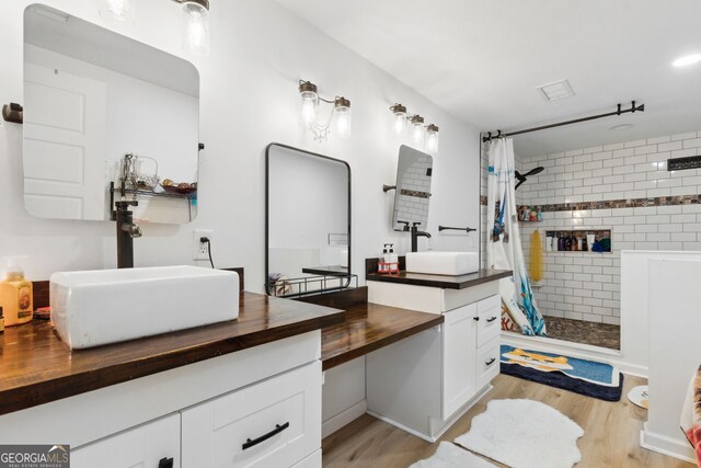 bathroom with walk in shower, wood-type flooring, and vanity