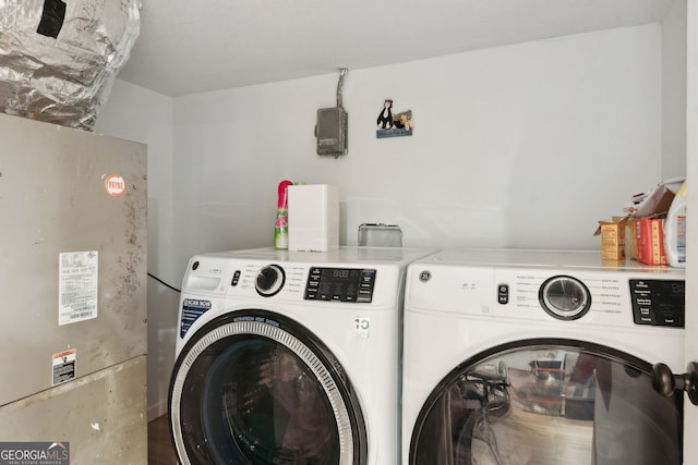 washroom featuring washing machine and clothes dryer and heating unit