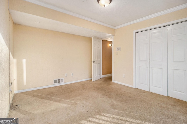 unfurnished bedroom featuring ornamental molding, carpet flooring, and a closet