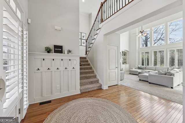 entryway featuring a high ceiling, ceiling fan, and light hardwood / wood-style flooring