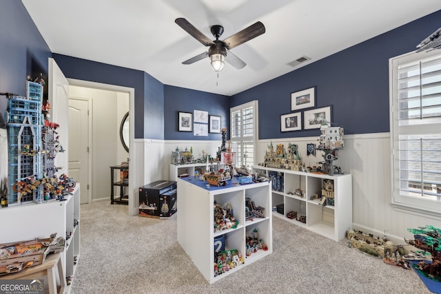 recreation room with plenty of natural light, light carpet, and ceiling fan