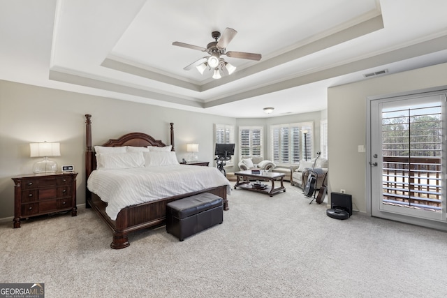 carpeted bedroom with crown molding, access to outside, ceiling fan, and a tray ceiling