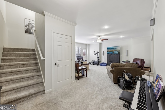 living room featuring ornamental molding, carpet, and ceiling fan