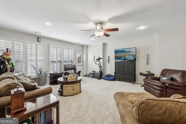 living room with ceiling fan, ornamental molding, and carpet flooring