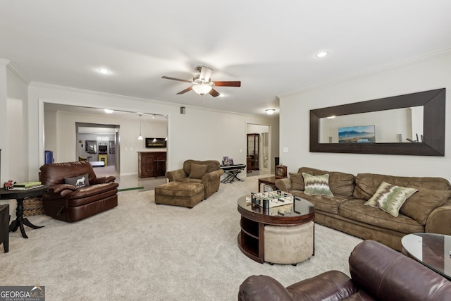 living room featuring ornamental molding, ceiling fan, and carpet flooring