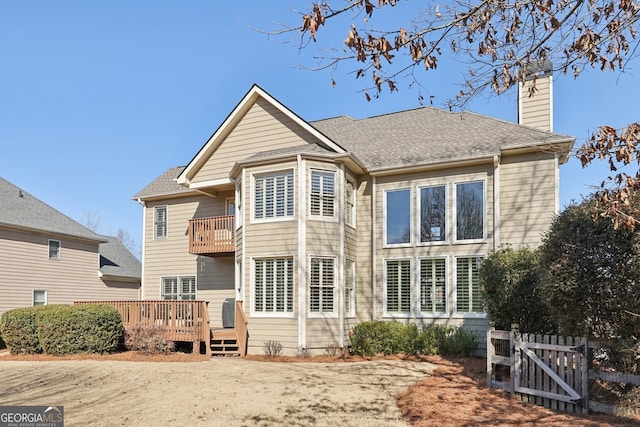 back of property featuring a wooden deck and a balcony