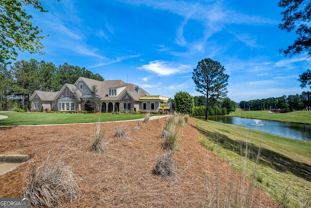 view of front of house with a front yard and a water view