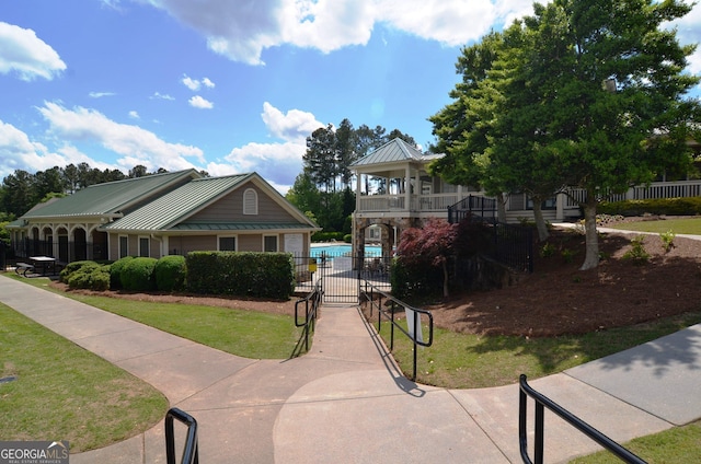 view of front of home with a balcony and a front lawn