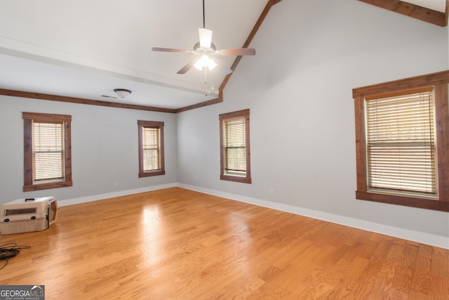 unfurnished room with ceiling fan, beam ceiling, high vaulted ceiling, heating unit, and light wood-type flooring