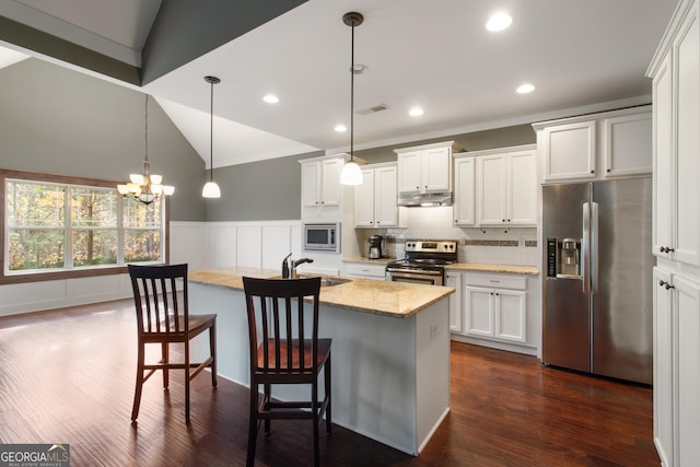 kitchen featuring lofted ceiling, white cabinetry, hanging light fixtures, a center island with sink, and stainless steel appliances