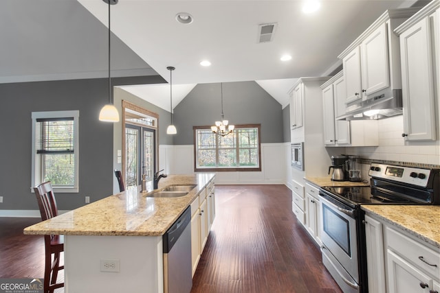 kitchen featuring an island with sink, lofted ceiling, sink, white cabinets, and stainless steel appliances