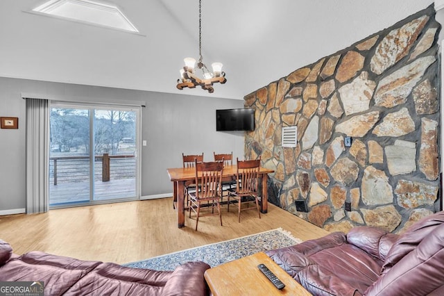 dining space with hardwood / wood-style flooring, lofted ceiling, and a chandelier