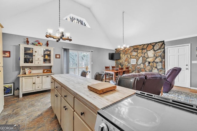 kitchen featuring an inviting chandelier, cream cabinets, vaulted ceiling, and hanging light fixtures