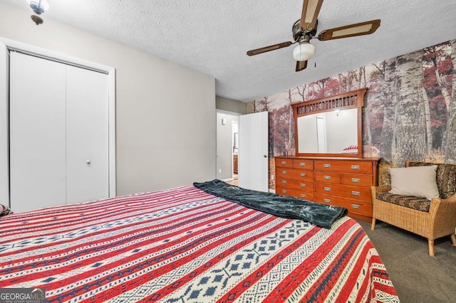 bedroom with ceiling fan, a textured ceiling, dark carpet, and a closet