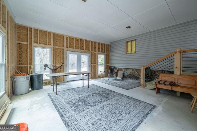 interior space featuring french doors, a healthy amount of sunlight, and concrete flooring