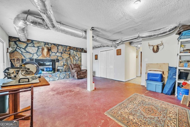 basement with a stone fireplace and a textured ceiling