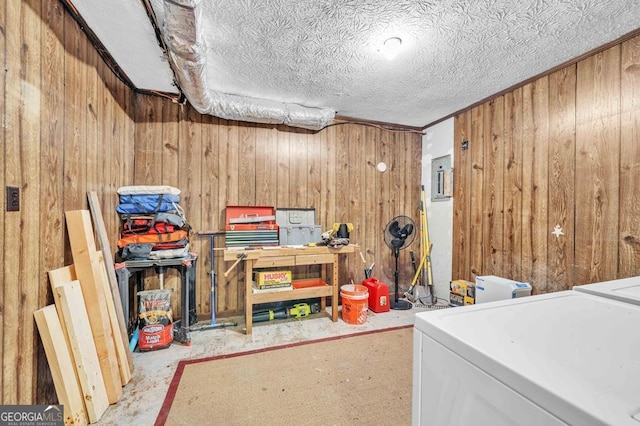 interior space with washer / clothes dryer, wooden walls, a workshop area, and a textured ceiling