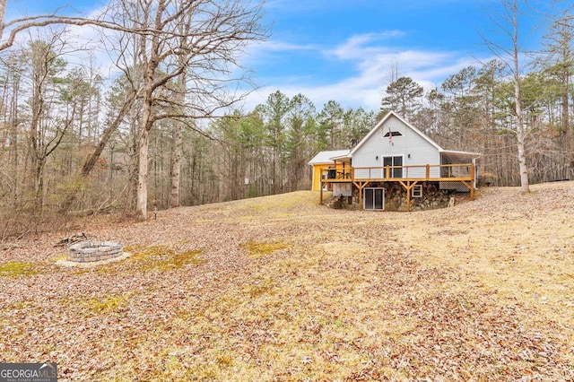 view of yard featuring a wooden deck and an outdoor fire pit