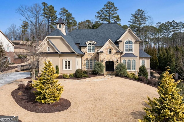 16143 Belford Dr, Alpharetta, GA 30004 - french country inspired facade with stone siding, stucco siding, and a standing seam roof