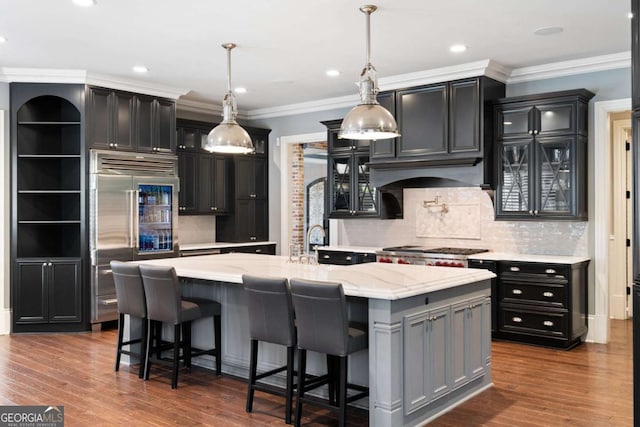 16143 Belford Dr, Alpharetta, GA 30004 - kitchen featuring built in fridge, glass insert cabinets, an island with sink, backsplash, and crown molding
